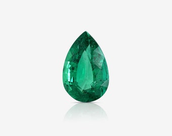 Puede incluir: Una piedra preciosa esmeralda de forma de pera, de color verde oscuro. La piedra preciosa está facetada y tiene un alto grado de brillo.