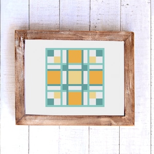 May include: A framed cross-stitch pattern with a geometric design featuring squares in shades of yellow, orange, and teal.
