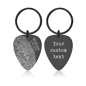 May include: Black guitar pick-shaped keychain. One side features a fingerprint design with the name "William" and the years "1952-2024". The other side has the text "Your custom text". The keychain has a black ring.