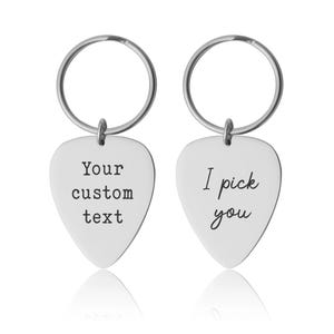 Könnte beinhalten: Zwei silberne Gitarrenplektrum-Schlüsselanhänger. Ein Schlüsselanhänger hat den Text "Your custom text" und der andere "I pick you". Beide Schlüsselanhänger haben oben einen silbernen Ring.