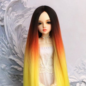 Puede incluir: Una peluca larga y recta para muñeca con un degradado de color degradado de negro a amarillo. La peluca está peinada con raya en medio y cae hasta la cintura de la muñeca.