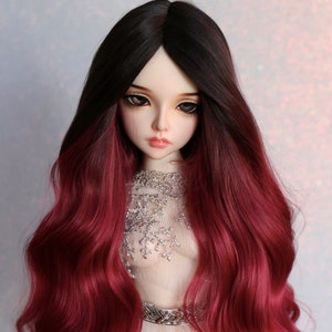Puede incluir: Una peluca larga y ondulada para muñeca con raíces negras que se desvanecen a un rojo burdeos profundo. La peluca está diseñada con ondas sueltas y es adecuada para una muñeca a escala 1/3.