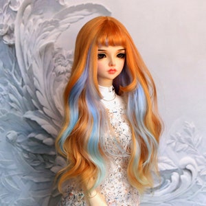 Puede incluir: Una peluca larga y ondulada para muñeca con rayas naranjas y azules. La peluca tiene flequillo y está peinada con raya lateral.