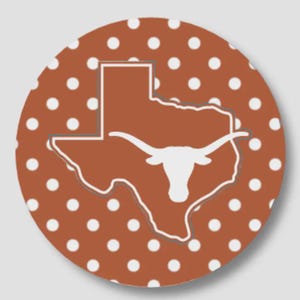 May include: A circular sticker featuring a burnt orange background with a repeating pattern of small white polka dots. Centered on the sticker is a white outline of the state of Texas containing a solid white silhouette of a longhorn steer head.