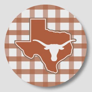 May include: A circular sticker featuring a burnt orange silhouette of the state of Texas with a white longhorn steer head graphic centered inside. The background consists of a light gray and burnt orange checkered gingham pattern.