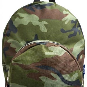 May include: A small, camouflage-patterned backpack with a rounded shape. The backpack features a front zippered pocket and a black handle. The camouflage design incorporates shades of green, brown, and black.