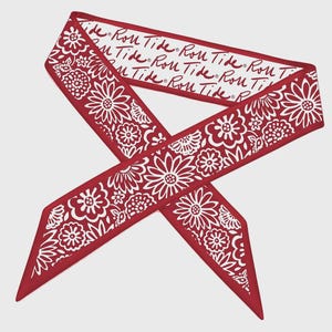 May include: Red and white floral patterned scarf with the text "Roll Tide" repeated along the top edge. The scarf features a repeating pattern of white flowers and leaves against a red background. The scarf is tied in a knot.