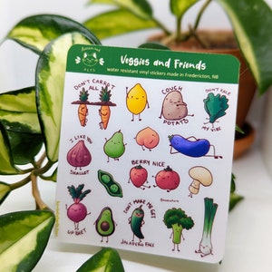 May include: A sheet of colourful, cartoon-style stickers featuring various vegetables with funny faces and phrases. The stickers include a carrot, lemon, potato, kale, fig, pear, strawberry, tomato, mushroom, beet, avocado, jalapeno, broccoli, and scallion. The text on the stickers includes "Don't Carrot All", "Couch Potato", "Don't Kale My Vibe", "I Like You Shallot", "Berry Nice", "Don't Make Me Get Jalapeno Face".