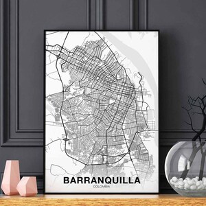 May include: Black and white framed map print of Barranquilla, Colombia. The map details the city's streets and layout. The city name is printed in a bold, sans-serif font at the bottom of the print.