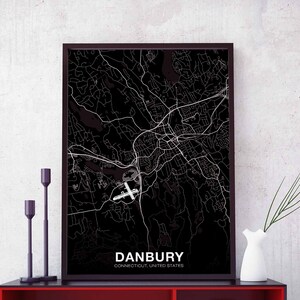 May include: Black and white map print of Danbury, Connecticut, United States. The map shows the city's streets and landmarks. The print is framed in a black frame.