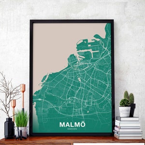 May include: A framed map of Malmö, Sweden, with a green city map on a beige background. The city name is printed in white at the bottom of the map.