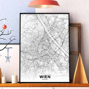 May include: A black and white map print of Wien, Austria. The map shows the city streets and landmarks. The print is framed and hanging on a wall.