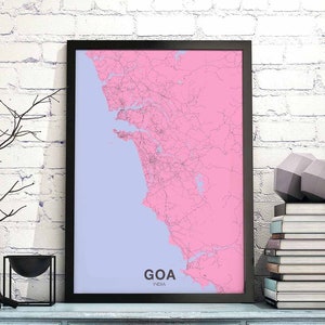 May include: A framed map of Goa, India, with a pink and light blue color scheme. The map shows the roads and coastline of the region. The word "GOA" is printed in black at the bottom of the map, with "INDIA" printed in smaller font below it.