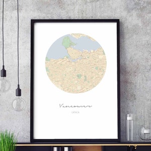 Può includere: Una stampa incorniciata nera di una mappa di Vancouver, Canada. La mappa è in un cerchio ed è in tonalità beige, verde e blu. Il testo "Vancouver, Canada" è stampato sotto la mappa.