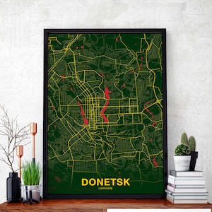 Puede incluir: Un mapa de Donetsk, Ucrania, en verde y amarillo con acentos rojos. El nombre de la ciudad está impreso en blanco en la parte inferior del mapa.