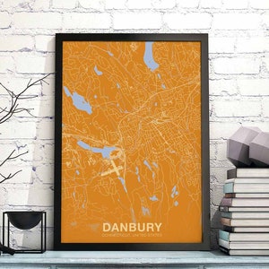 May include: A framed map of Danbury, Connecticut, United States. The map is printed on a light orange background with dark brown lines representing streets and roads. The map is surrounded by a black frame.
