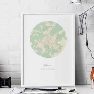 May include: A white framed print of a map of Foča, Bosnia & Herzegovina. The map is in a circle with a green and beige color scheme. The city name is written in cursive at the bottom of the print.