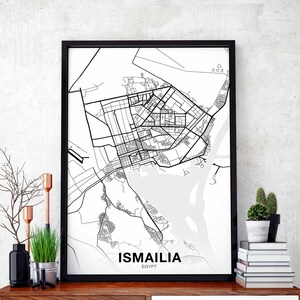 May include: Black and white city map print of Ismailia, Egypt in a black frame. The map shows the city's streets and waterways.