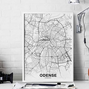 May include: A black and white map print of Odense, Denmark, in a white frame. The map shows the city's streets and landmarks.