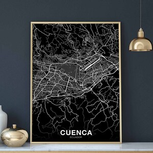 May include: A black and white map print of Cuenca, Ecuador, with the city name and country printed at the bottom of the map. The map is framed in a gold frame.