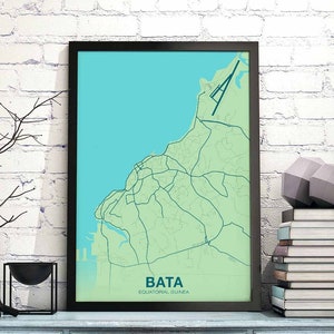 May include: A framed map of Bata, Equatorial Guinea, with a light green background and dark blue lines showing the roads and a light blue body of water. The map is framed in black.