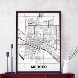May include: A black and white map print of Merced, California, United States. The map shows the city's street grid and is framed in a black frame.
