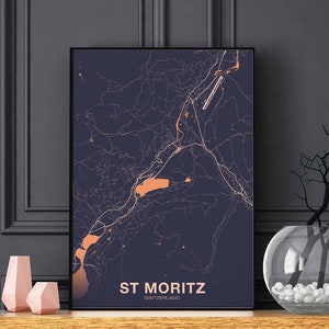 May include: A navy blue poster with a map of St. Moritz, Switzerland. The map is in a light peach color. The text "St. Moritz" and "Switzerland" is in a light peach color at the bottom of the poster.