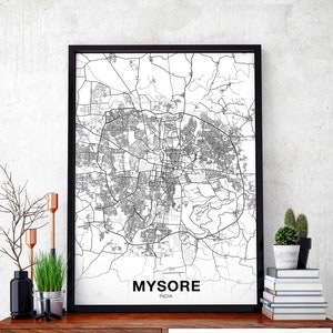 May include: Black framed map print of Mysore, India. The map is a detailed black and white illustration of the city's layout, including roads and buildings. The city name and country are printed in a clean, modern font at the bottom of the print.
