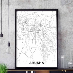 May include: Black and white line art map print of Arusha, Tanzania. The map shows the city streets and roads. The print is framed in a black frame.