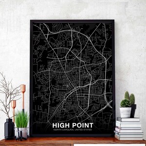 Può includere: Stampa di mappa in bianco e nero di High Point, Carolina del Nord, Stati Uniti. La mappa è incorniciata da una cornice nera ed è appesa a un muro.