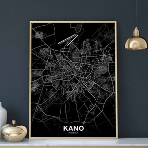 Könnte beinhalten: Ein Schwarzweiß-Stadtplan-Druck von Kano, Nigeria. Die Karte ist in einem goldenen Rahmen gerahmt und hängt an einer dunkelgrauen Wand.