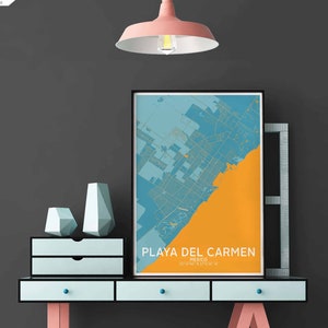 Puede incluir: Un mapa enmarcado de Playa del Carmen, M&eacute;xico, con un esquema de color azul y naranja, colgado en una pared gris sobre una c&oacute;moda azul claro con dos cajones. La c&oacute;moda est&aacute; sobre un soporte de metal negro con patas rosas. Hay dos jarrones de forma geom&eacute;trica en la c&oacute;moda.