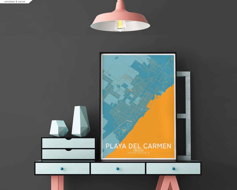 Puede incluir: Un mapa enmarcado de Playa del Carmen, M&eacute;xico, con un esquema de color azul y naranja, colgado en una pared gris sobre una c&oacute;moda azul claro con dos cajones. La c&oacute;moda est&aacute; sobre un soporte de metal negro con patas rosas. Hay dos jarrones de forma geom&eacute;trica en la c&oacute;moda.