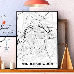 Pode incluir: Impressão de mapa preto e branco de Middlesbrough, Grã-Bretanha. O mapa mostra as ruas da cidade e os arredores. A impressão está emoldurada em uma moldura preta e está pendurada em uma parede.