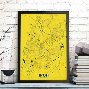 Pode incluir: Uma impressão emoldurada preta de um mapa amarelo de Ipoh, Malásia. O mapa mostra as ruas e pontos de referência da cidade em azul escuro. O nome da cidade "Ipoh" e "Malásia" estão impressos em azul escuro na parte inferior do mapa.