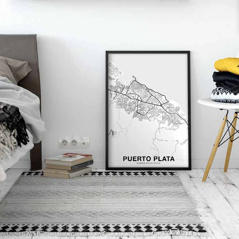 Puede incluir: Impresi&oacute;n de mapa en blanco y negro de Puerto Plata, Rep&uacute;blica Dominicana, en un marco negro. El mapa muestra las calles de la ciudad y los alrededores. La impresi&oacute;n est&aacute; colgada en una pared blanca en una habitaci&oacute;n con una cama y una mesita de noche.