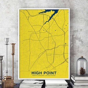 Può includere: Una stampa di mappa di High Point, Carolina del Nord, Stati Uniti, in giallo e blu. La mappa è incorniciata in una cornice bianca ed è appesa a un muro grigio.