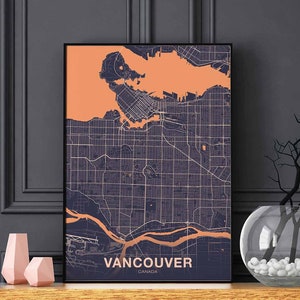 Può includere: Una stampa incorniciata nera di una mappa di Vancouver, Canada. La mappa è di colore blu scuro con accenti arancioni. Il testo "Vancouver, Canada" è stampato nella parte inferiore della mappa.