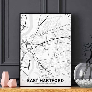 Peut inclure: Impression d'une carte d'East Hartford, Connecticut, États-Unis, en noir et blanc. La carte est encadrée d'un cadre noir et est exposée sur une étagère avec un vase et des objets décoratifs.