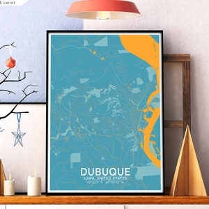May include: A printable map of Dubuque, Iowa, United States, with a blue background and yellow river. The map shows the city's streets and landmarks. The text "DUBUQUE" is printed in large, bold letters at the bottom of the map, along with the coordinates "42°30'2" N 80°39'52" W".
