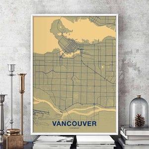 Può includere: Una stampa di mappa vintage di Vancouver, Canada. La mappa è in tonalità di verde e blu su uno sfondo beige. Il nome della città è stampato in blu nella parte inferiore della mappa.