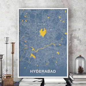 May include: A blue and white map print of Hyderabad, India. The map is framed in a white frame and the city name is printed in yellow at the bottom.