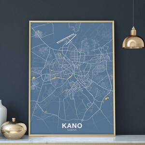 Könnte beinhalten: Ein blauer und weißer Stadtplan von Kano, Nigeria, in einem goldenen Rahmen. Die Karte zeigt die Straßen und Sehenswürdigkeiten der Stadt.