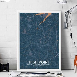 Può includere: Una stampa di mappa incorniciata di High Point, Carolina del Nord, con uno sfondo blu scuro e accenti arancioni e grigi. Il testo "HIGH POINT" e "NORTH CAROLINA, UNITED STATES" è stampato sotto la mappa.