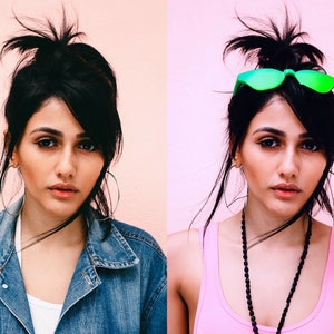 May include: A woman with dark hair pulled back in a high ponytail is wearing a denim jacket and a white vest top. She is looking at the camera with a serious expression.