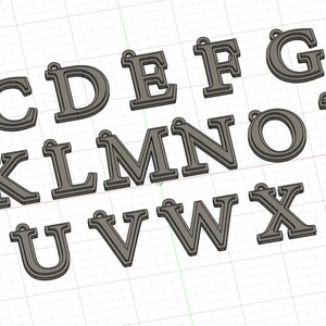 May include: A collection of individual gray letter charms from A to Z, each featuring a raised border and a small loop at the top for attachment. The letters are arranged in three rows against a light grid background, showcasing a uniform design.