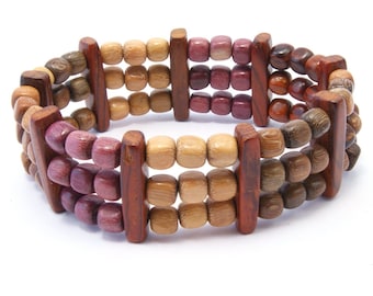 Puede incluir: Un brazalete de madera multicolor con tres filas de cuentas. Las cuentas son en tonos de marrón, beige y morado.