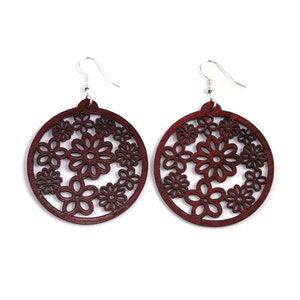 May include: A pair of maroon wooden earrings with a circular design featuring a floral pattern.