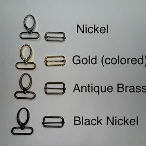 K&ouml;nnte beinhalten: Vier Sets aus Metallbeschl&auml;gen, jeweils bestehend aus einem drehbaren Karabinerhaken und einer rechteckigen Schiebeschnalle. Die Oberfl&auml;chen sind als Nickel, Gold (colored), Antique Brass und Black Nickel beschriftet und in Reihen angeordnet.