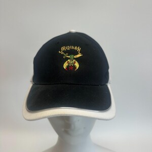 May include: Black baseball cap with a white brim and silver trim. The cap has the embroidered word "Medinah" in gold above a colourful emblem. The cap is designed with a curved brim and a structured crown.